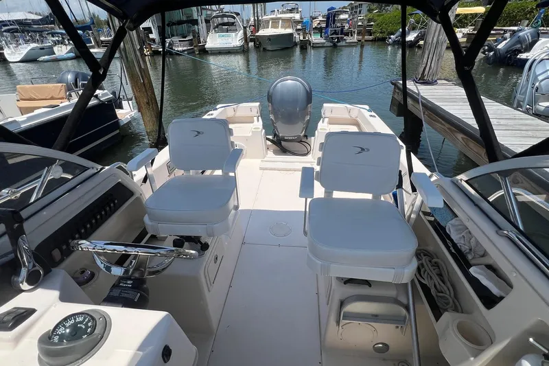 Slide: The Image of 2005 Grady-White Seafarer 226 boat interior at marina, featuring dual seats and steering console. - 6
