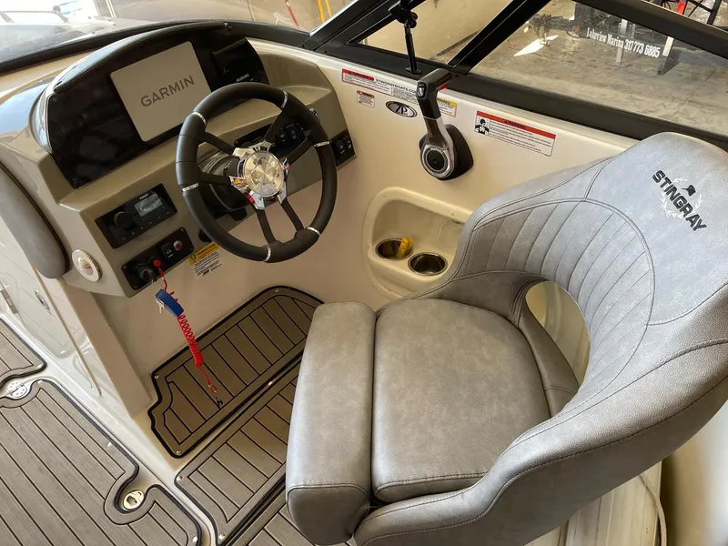 Slide: The Image of 2022 Stingray 231 DC boat cockpit with Garmin display and comfortable seating. - 11