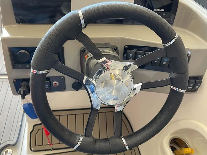 Slide: The Image of Steering wheel of 2022 Stingray 231 DC boat, featuring modern controls and design. - 12