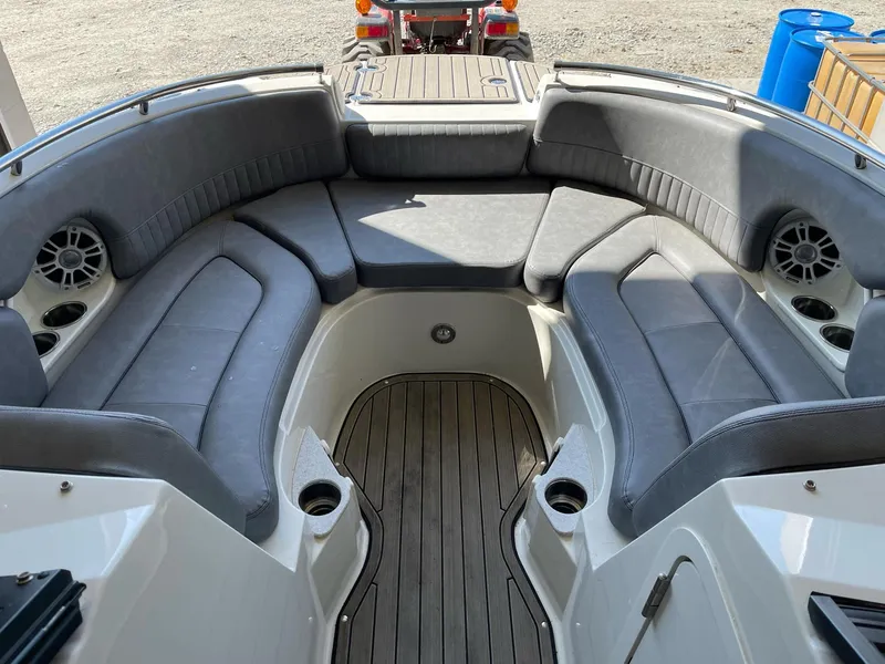 Slide: The Image of 2022 Stingray 231 DC boat interior with gray seating and wood flooring. - 21
