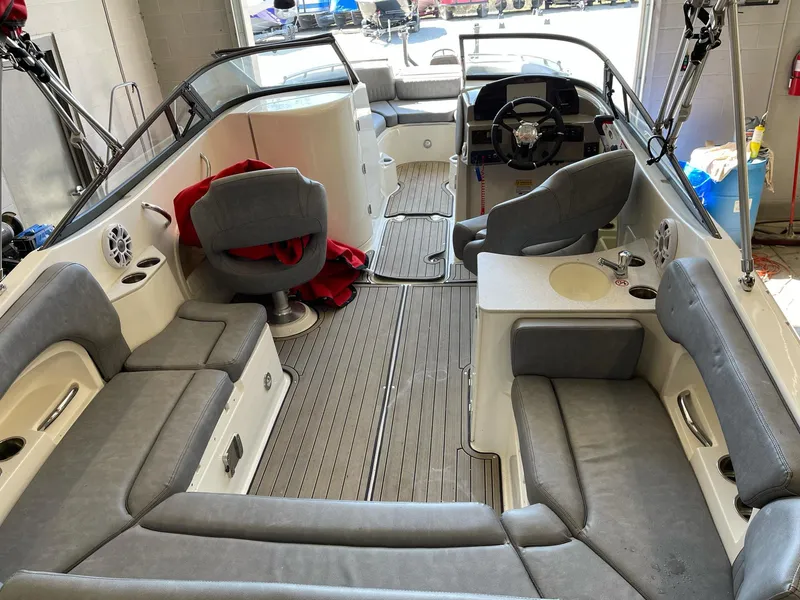 Slide: The Image of 2022 Stingray 231 DC boat interior with gray seating and modern dashboard. - 7