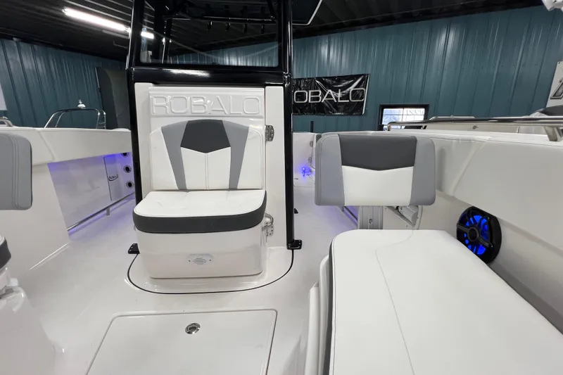 Slide: The Image of 2025 Robalo R250 Center Console boat interior with sleek black design in showroom. - 12