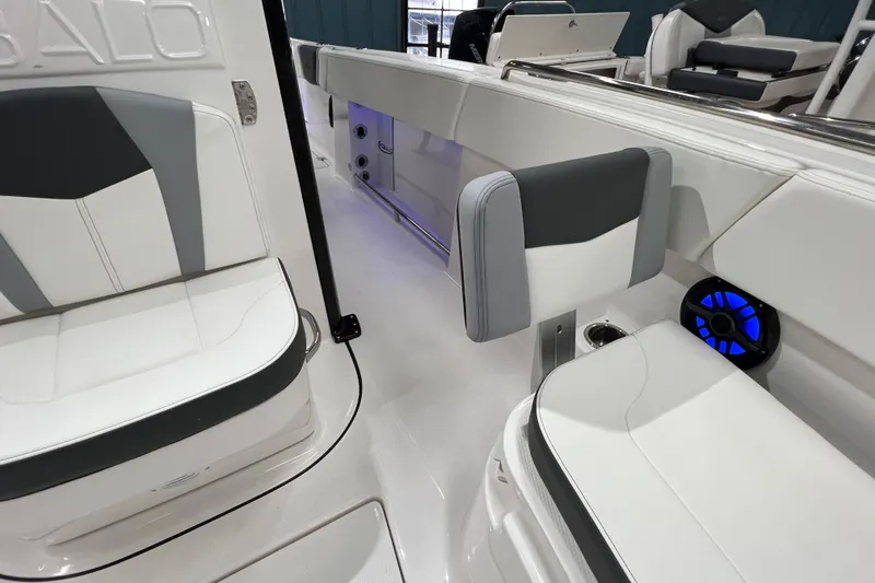 Slide: The Image of 2025 Robalo R250 Center Console boat interior with overhead lighting in a showroom. - 13