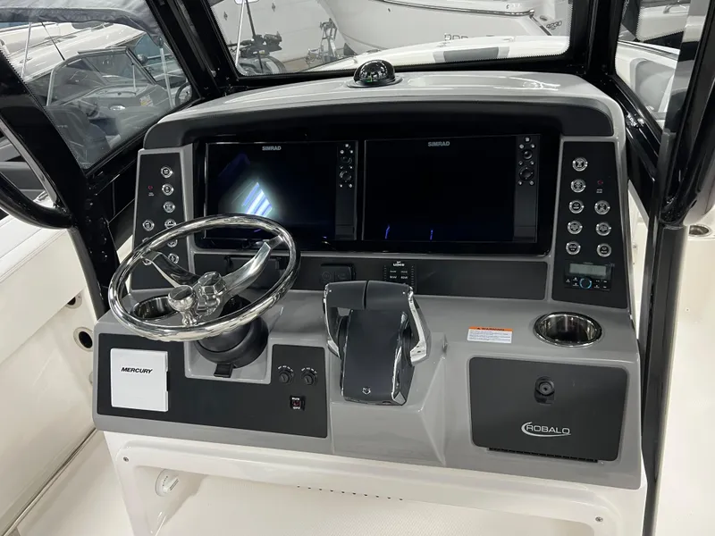 Slide: The Image of 2025 Robalo R250 Center Console boat interior with seating and console in a showroom. - 4