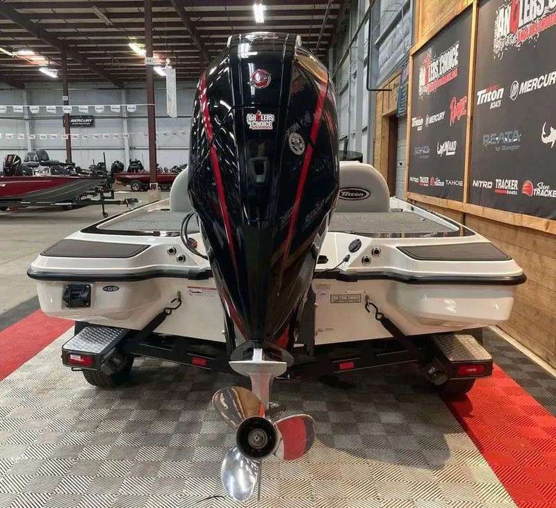 Slide: The Image of 2024 Triton 20XP boat with powerful outboard motor in showroom setting. - 3