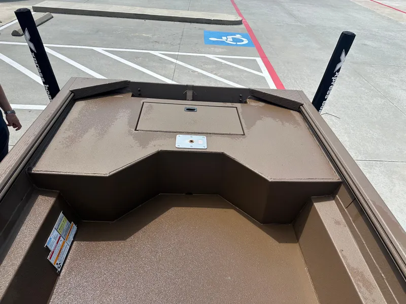 Slide: The Image of 2025 Xpress HD16DBX boat interior with storage compartment, parked in a lot. - 17