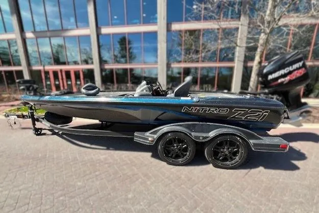 Slide: The Image of 2018 Nitro Z21 boat with trailer, parked outdoors near a building. - 0
