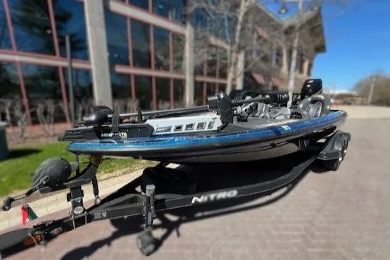 Slide: The Image of 2018 Nitro Z21 boat on trailer, parked near modern building. - 3