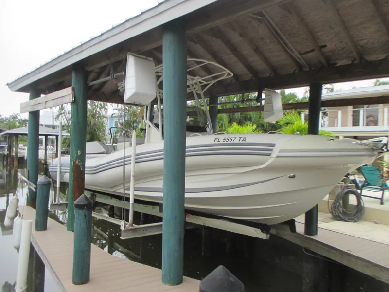 Slide: The Image of 2021 Zodiac NZO 760 boat docked under a wooden shelter. - 2