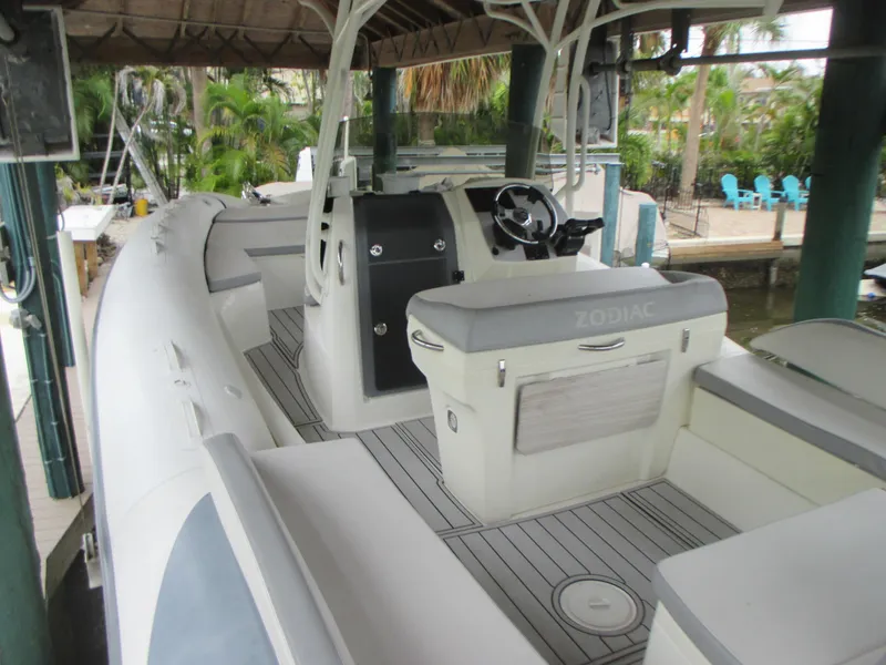 Slide: The Image of 2021 Zodiac NZO 760 boat interior with steering console and seating under a canopy. - 6