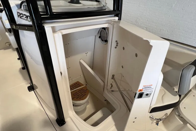 Slide: The Image of 2025 Robalo R230 Center Console boat interior with open storage compartment. - 17