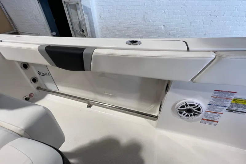 Slide: The Image of 2025 Robalo R230 Center Console interior with white seating and speaker detail. - 18