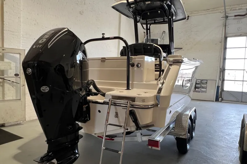 Slide: The Image of 2025 Robalo R230 Center Console boat with powerful outboard engine in a garage setting. - 6