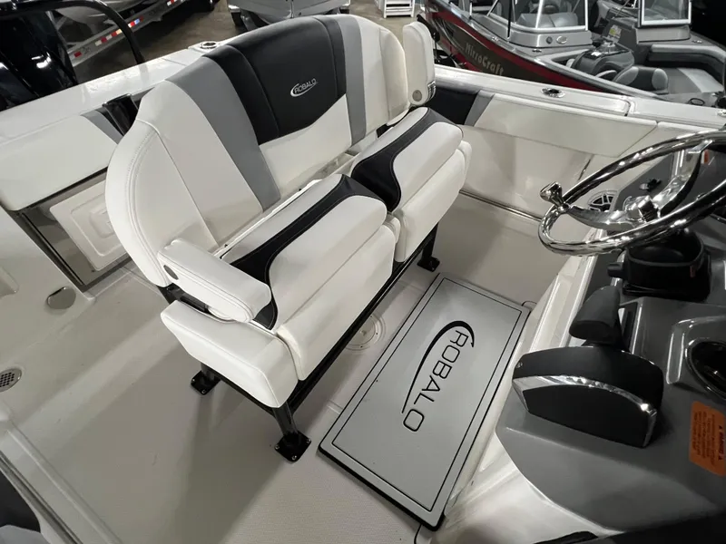 Slide: The Image of 2025 Robalo R230 Center Console boat interior with dual seating and steering wheel. - 9