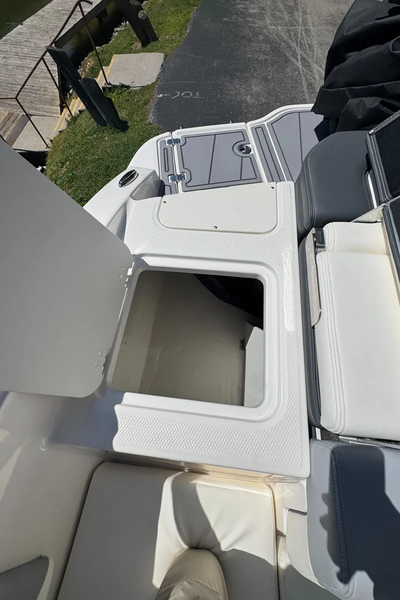 Slide: The Image of 2024 Chaparral 21 SSi boat with open storage compartment lid. - 10