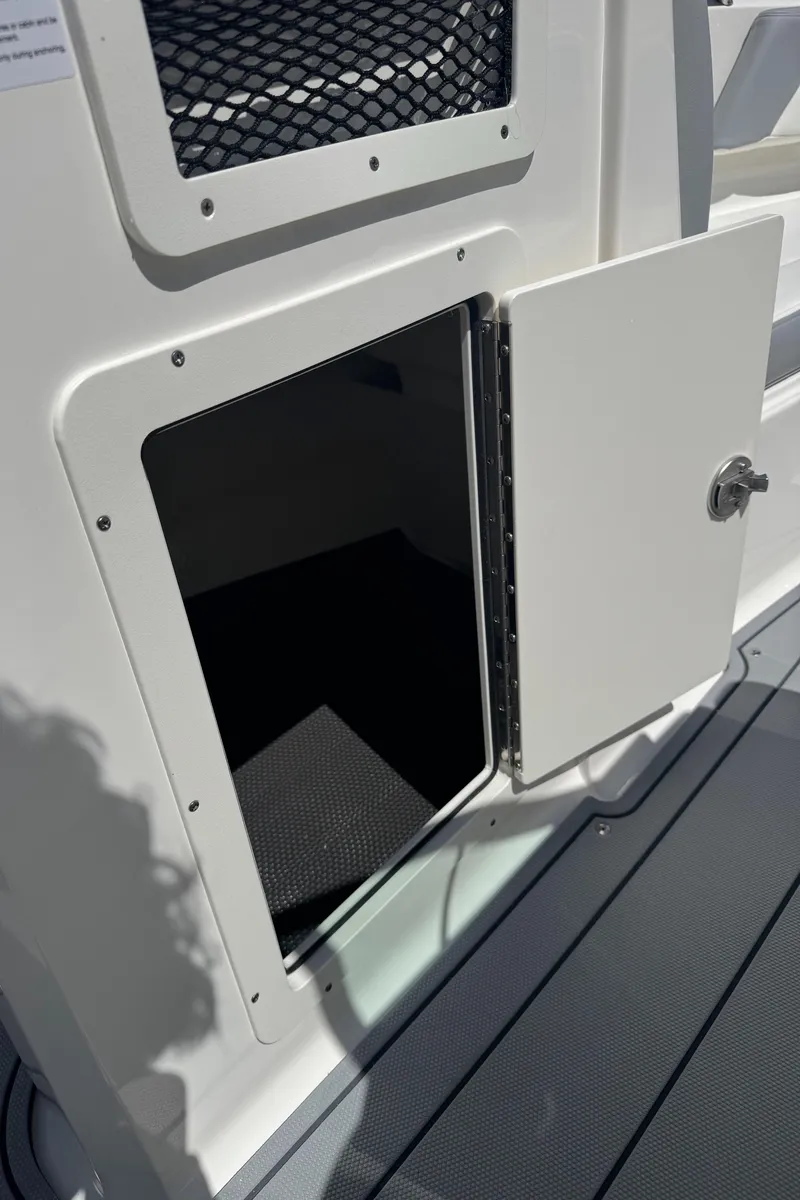 Slide: The Image of 2024 Chaparral 21 SSi boat door with storage compartment. - 21