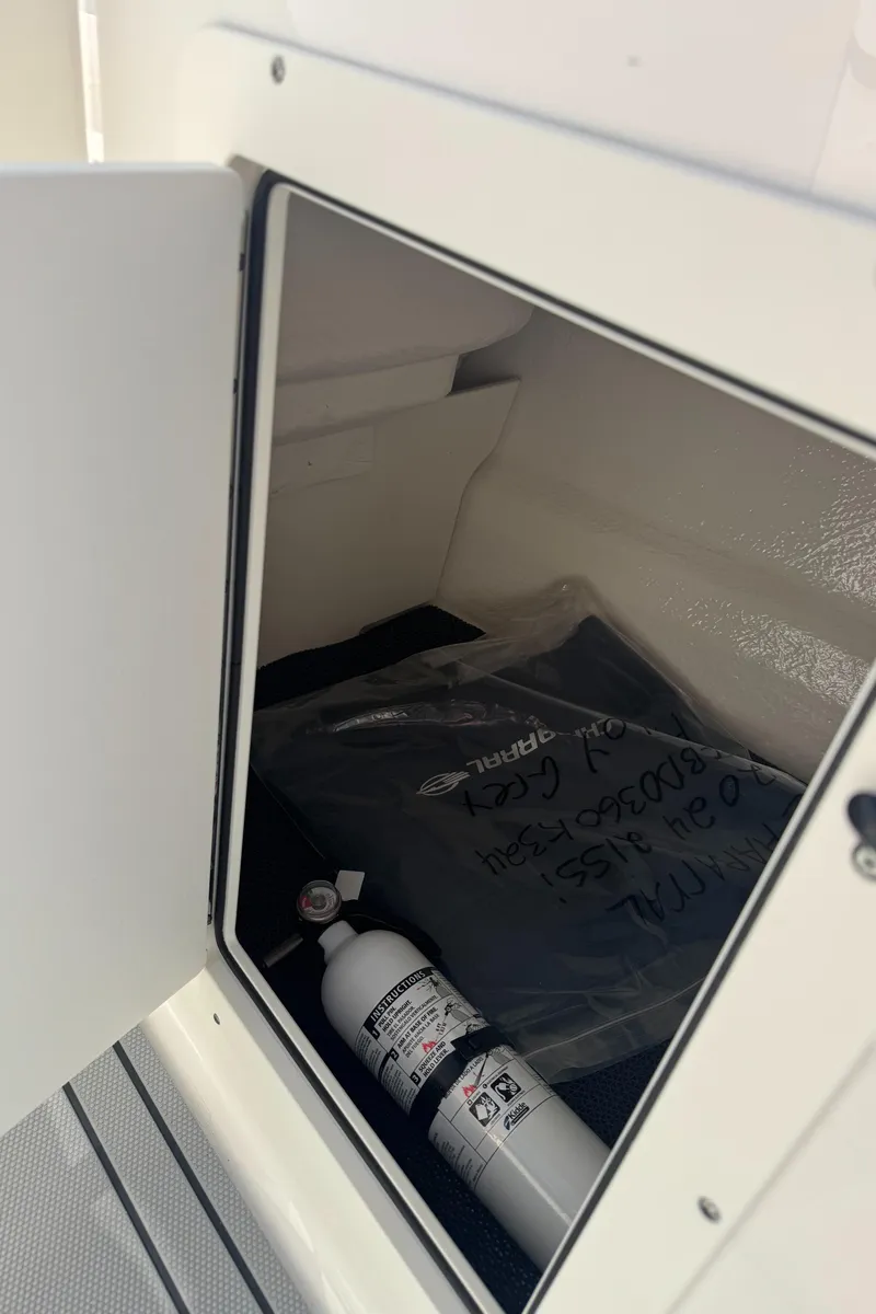 Slide: The Image of Storage compartment in 2024 Chaparral 21 SSi with fire extinguisher. - 24