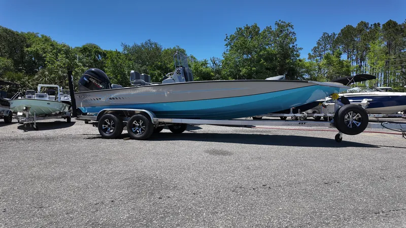 Slide: The Image of 2025 Xpress H22B boat on trailer, blue and gray, parked outdoors. - 0