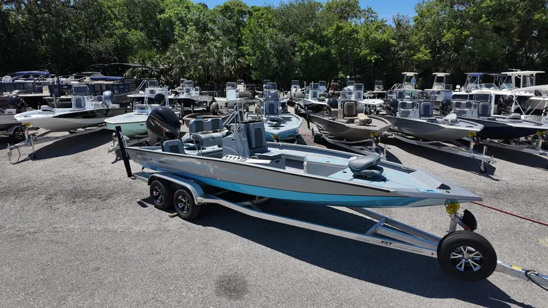 Slide: The Image of 2025 Xpress H22B boat on trailer in a marina with multiple boats. - 1