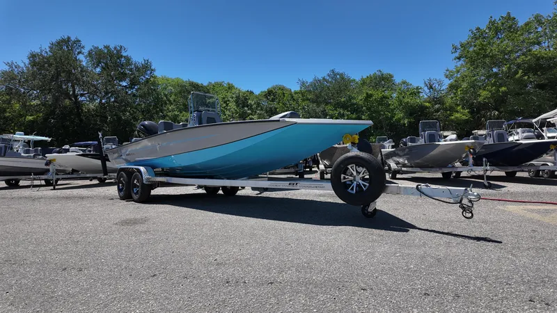 Slide: The Image of 2025 Xpress H22B boat on trailer in sunny outdoor setting. - 2