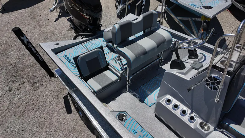 Slide: The Image of 2025 Xpress H22B boat interior with seating, steering wheel, and console features. - 24
