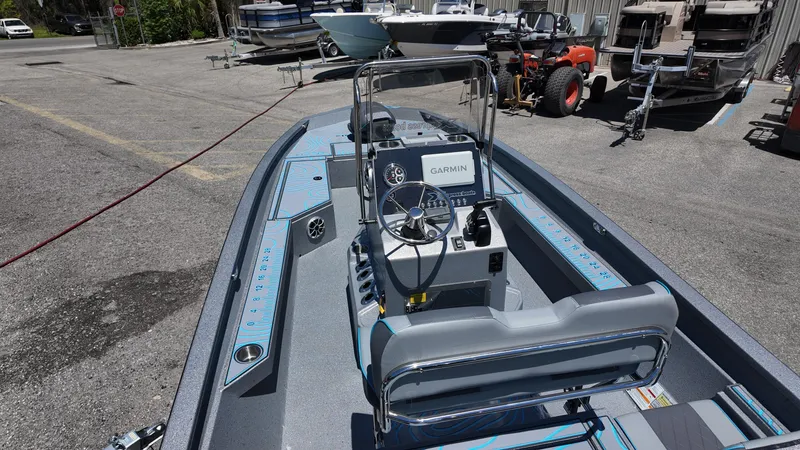 Slide: The Image of 2025 Xpress H22B boat with Garmin system, parked outdoors, showcasing interior and steering console. - 31