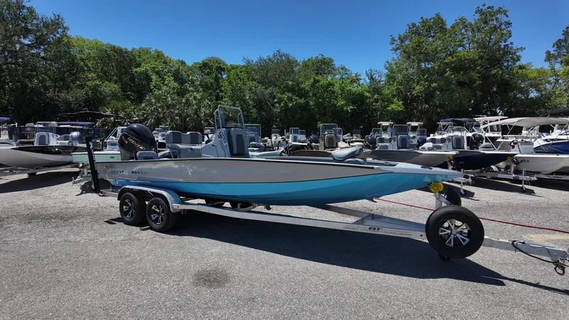 Slide: The Image of 2025 Xpress H22B boat on trailer in sunny outdoor showroom. - 6