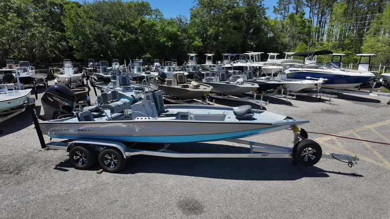 Slide: The Image of 2025 Xpress H22B boat on trailer in a marina with multiple boats. - 8