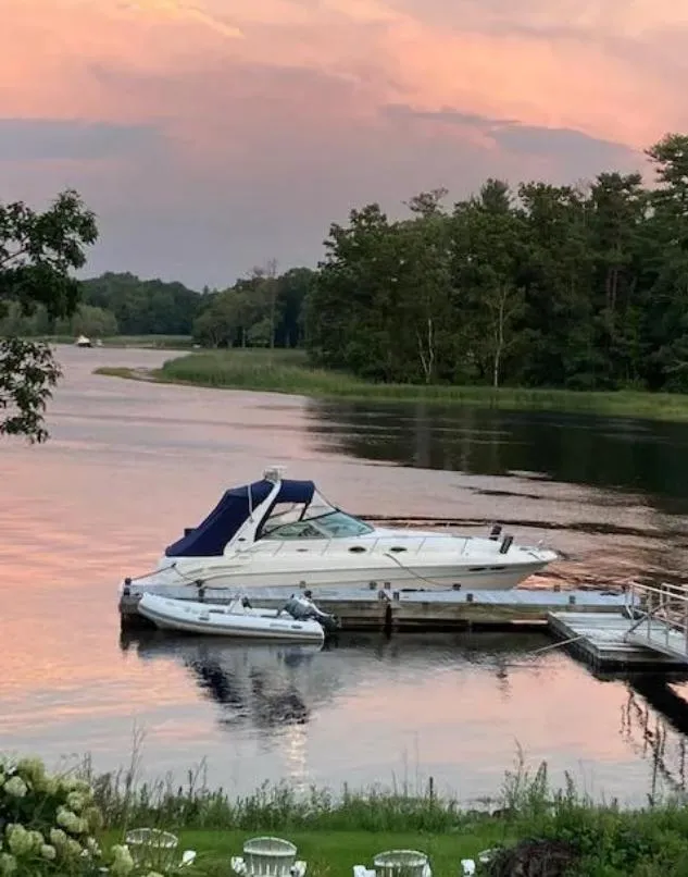 The Image of 2002 Sea Ray 340 Sundancer docked on serene lake at sunset. - 0