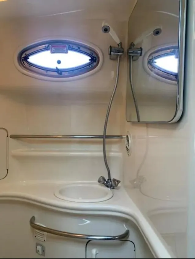 Slide: The Image of 2002 Sea Ray 340 Sundancer bathroom with sink, mirror, and porthole window. - 11