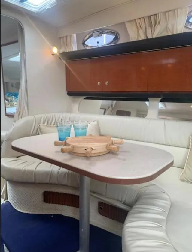 Slide: The Image of Interior of 2002 Sea Ray 340 Sundancer yacht with cozy seating and table setup. - 7