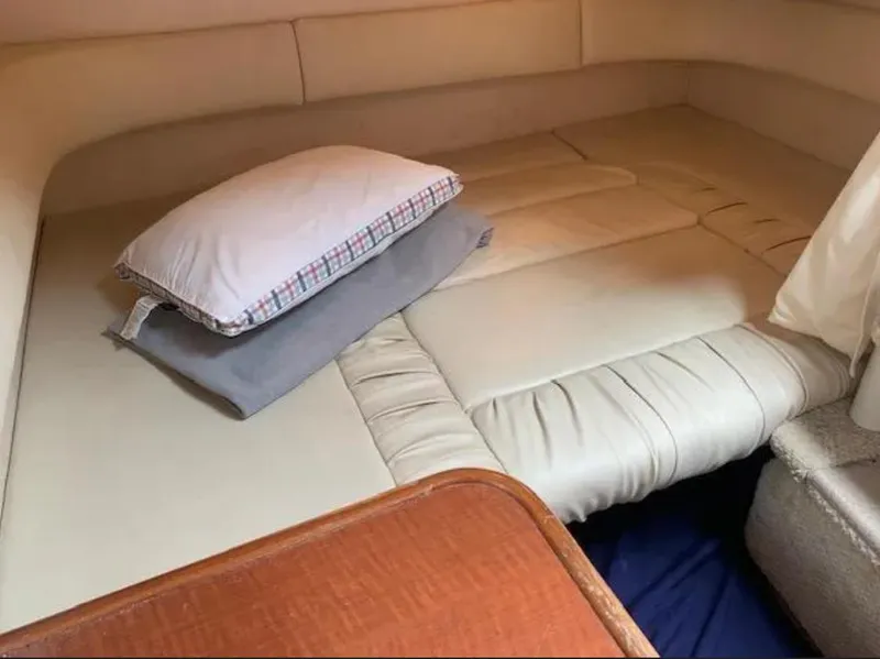 Slide: The Image of 2002 Sea Ray 340 Sundancer cabin interior with beige cushions and pillows. - 9