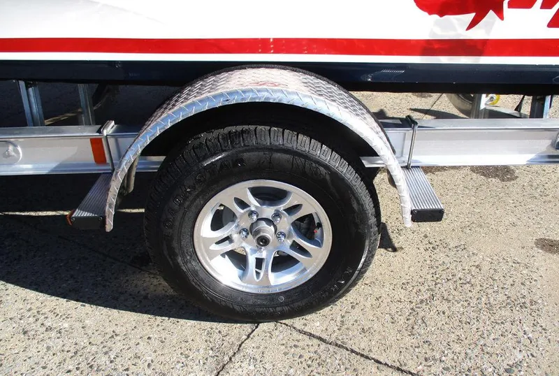 Slide: The Image of 2025 Mako 18 Pro Skiff Patriot Edition trailer wheel on concrete surface. - 12