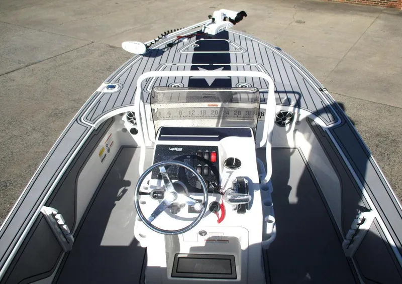 Slide: The Image of 2025 Mako 18 Pro Skiff Patriot Edition boat interior with steering console and deck view. - 6