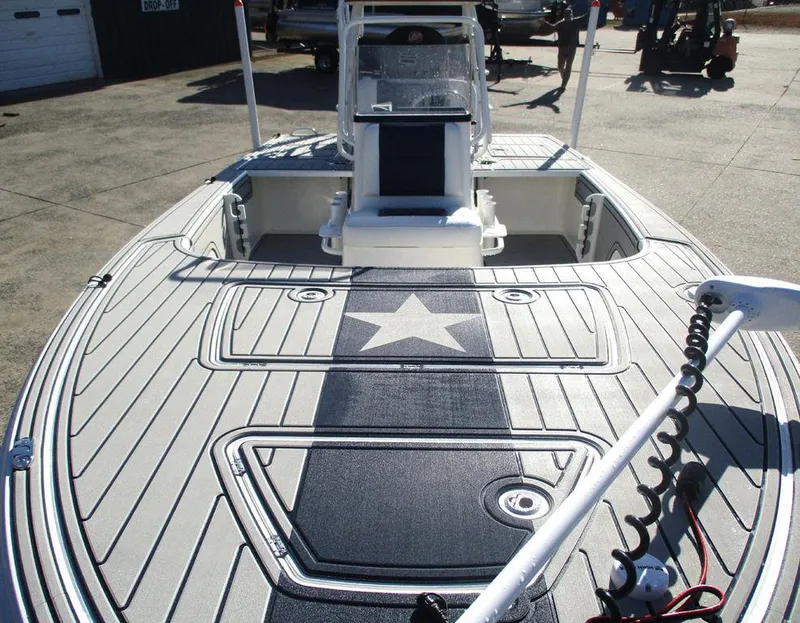Slide: The Image of 2025 Mako 18 Pro Skiff Patriot Edition with star design on deck, docked outdoors. - 9