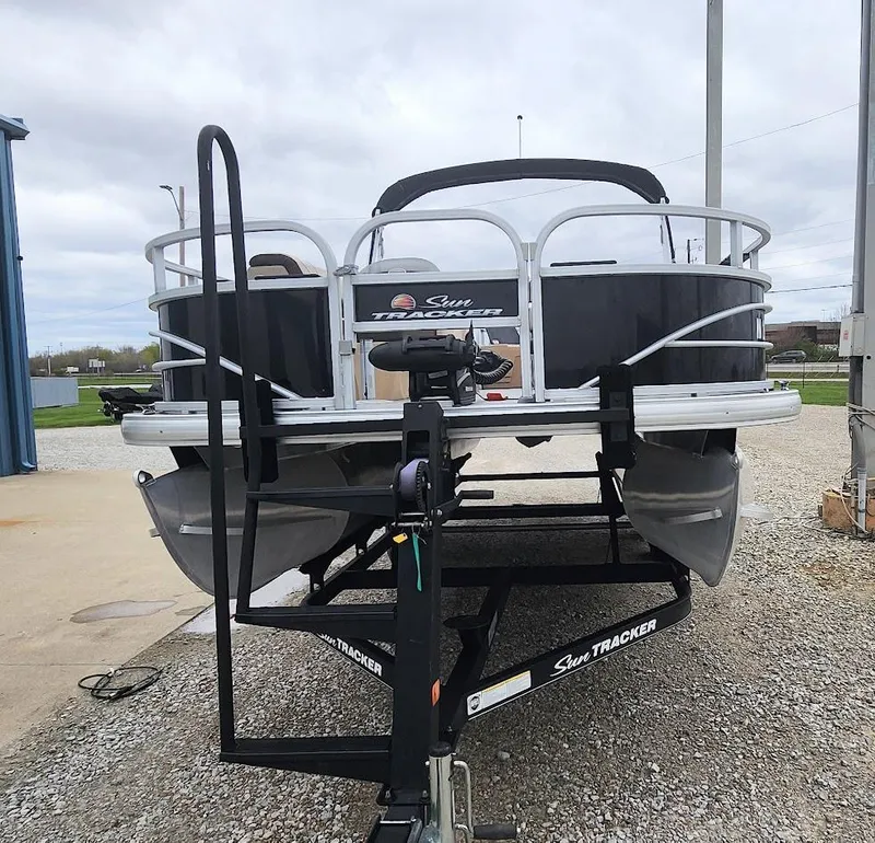 Slide: The Image of 2018 Sun Tracker Fishin' Barge 20 DLX pontoon boat on trailer, parked outdoors. - 3