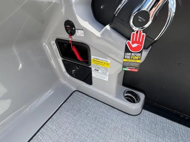 Slide: The Image of 2025 Harris Sunliner 230 boat console with throttle, warning tag, and cup holder. - 24