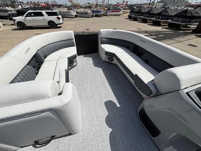 Slide: The Image of 2025 Harris Sunliner 230 pontoon boat with spacious seating, docked at a marina. - 29