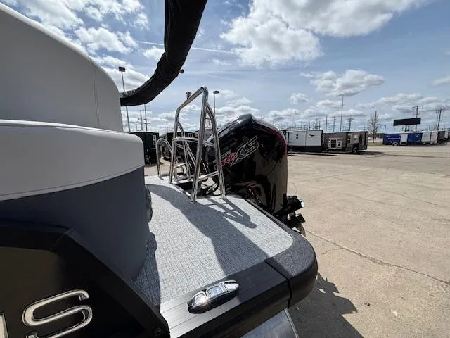 Slide: The Image of 2025 Harris Sunliner 230 boat with outboard motor, parked on a sunny day. - 4