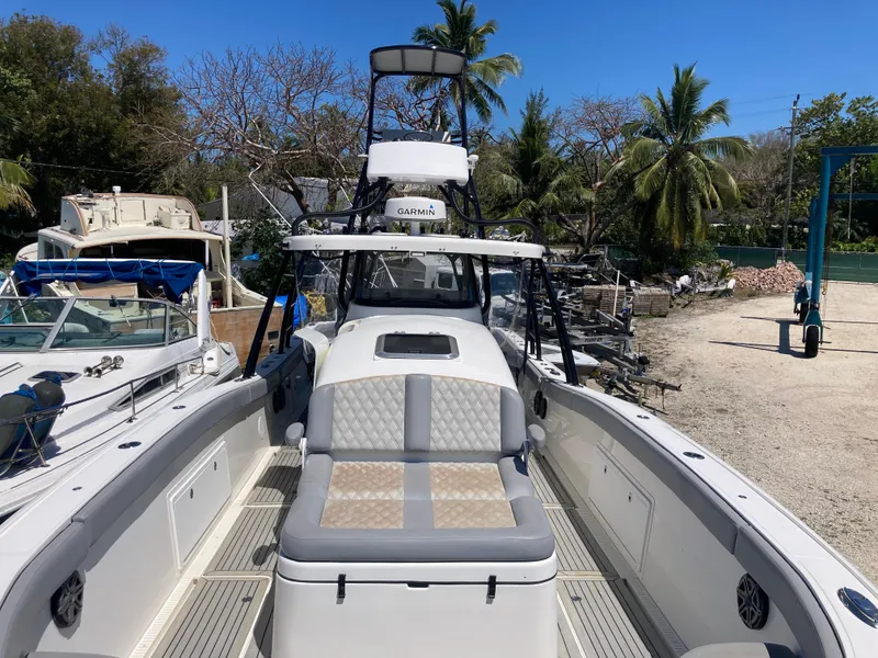 Slide: The Image of 2014 Insetta i45C boat with seating, docked near palm trees and other boats. - 22