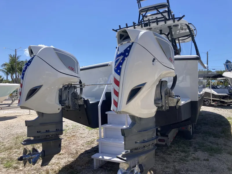 Slide: The Image of 2014 Insetta i45C boat with dual outboard engines, American flag design, parked outdoors. - 28