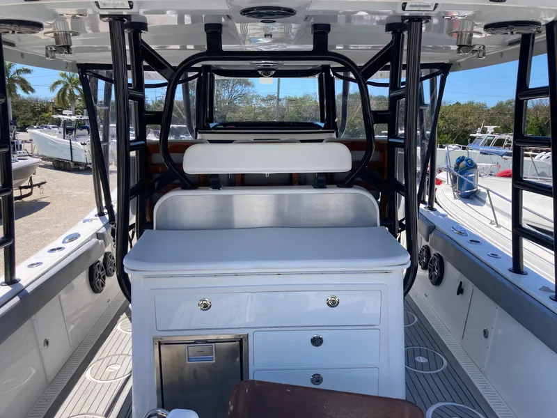 Slide: The Image of 2014 Insetta i45C boat interior with seating and storage, docked under clear skies. - 5