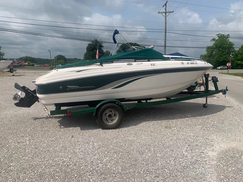 Slide: The Image of 2000 Chaparral 196 SSi boat on trailer, parked on gravel, under cloudy sky. - 0