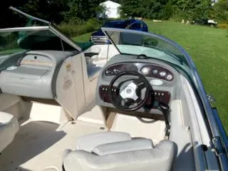 Slide: The Image of 2000 Chaparral 196 SSi boat interior with steering wheel and seating, parked on grass. - 14