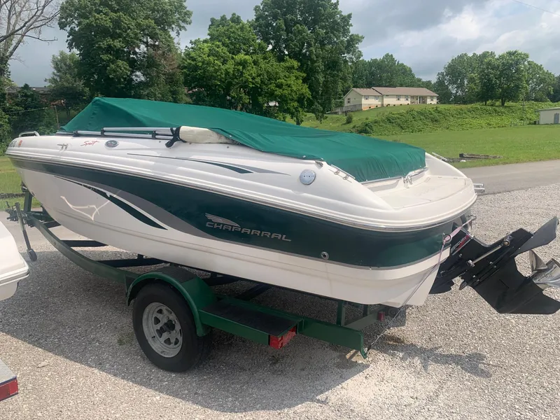 Slide: The Image of Chaparral 196 SSi 2000 boat on trailer with green cover, parked outdoors. - 3