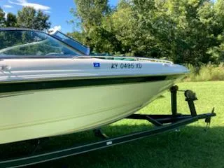 Slide: The Image of Chaparral 196 SSi 2000 boat on trailer, parked on grass with trees in background. - 9