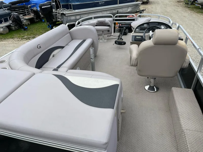 Slide: The Image of 2014 Grand Island 2085 QF pontoon boat interior with beige seating and steering console. - 7