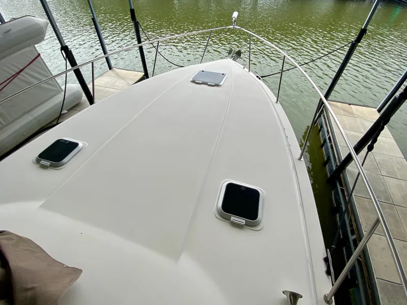 Slide: The Image of 2006 Rinker 360 Fiesta Vee boat docked, showing spacious deck and water view. - 19