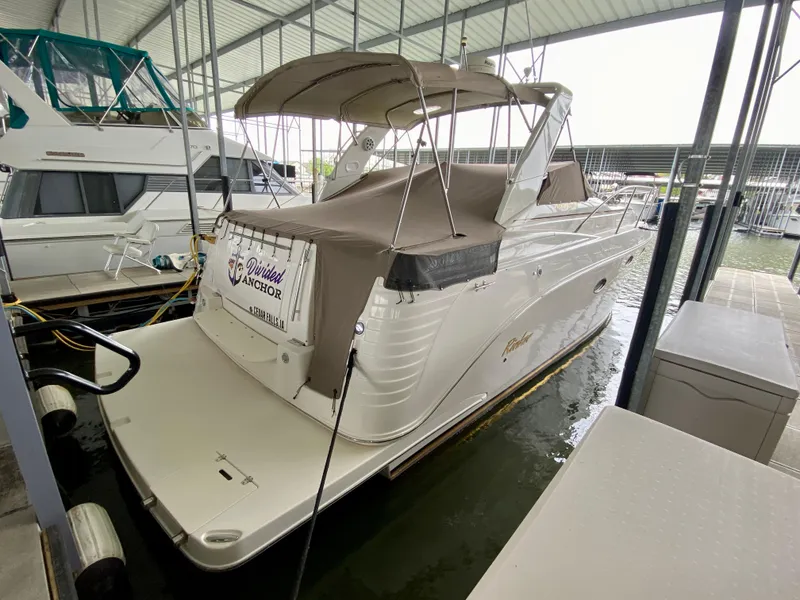 Slide: The Image of 2006 Rinker 360 Fiesta Vee boat docked under a covered marina. - 2