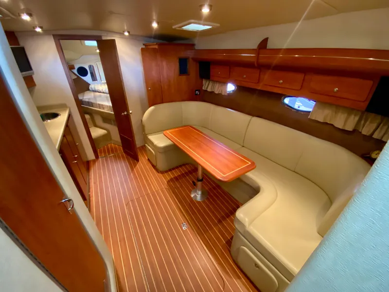 Slide: The Image of 2006 Rinker 360 Fiesta Vee interior with wood flooring and beige seating. - 22